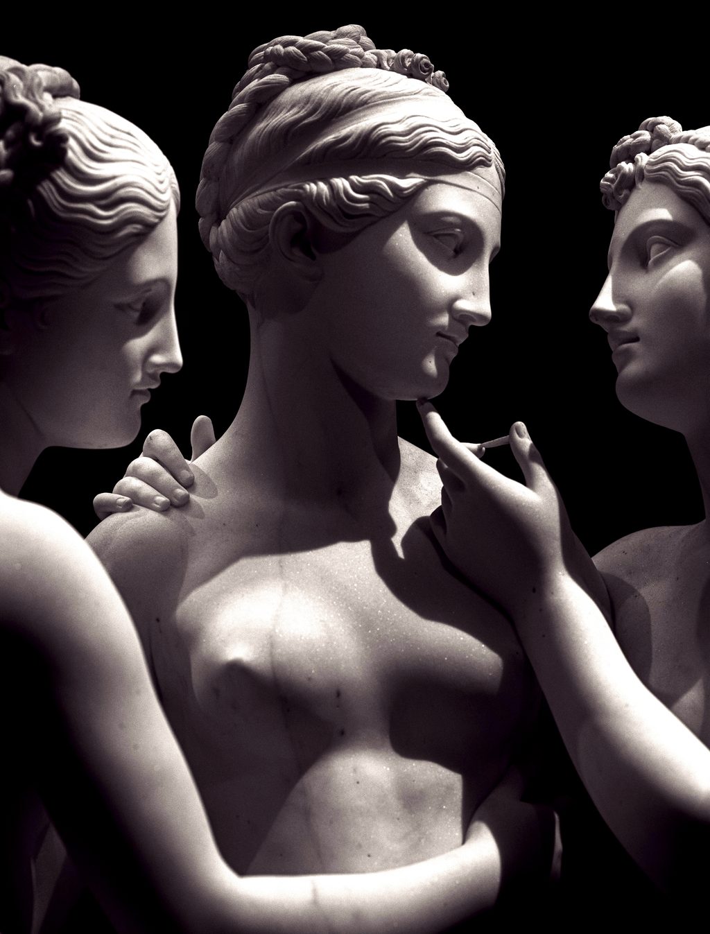 Escultura clásica de mármol con tres figuras femeninas